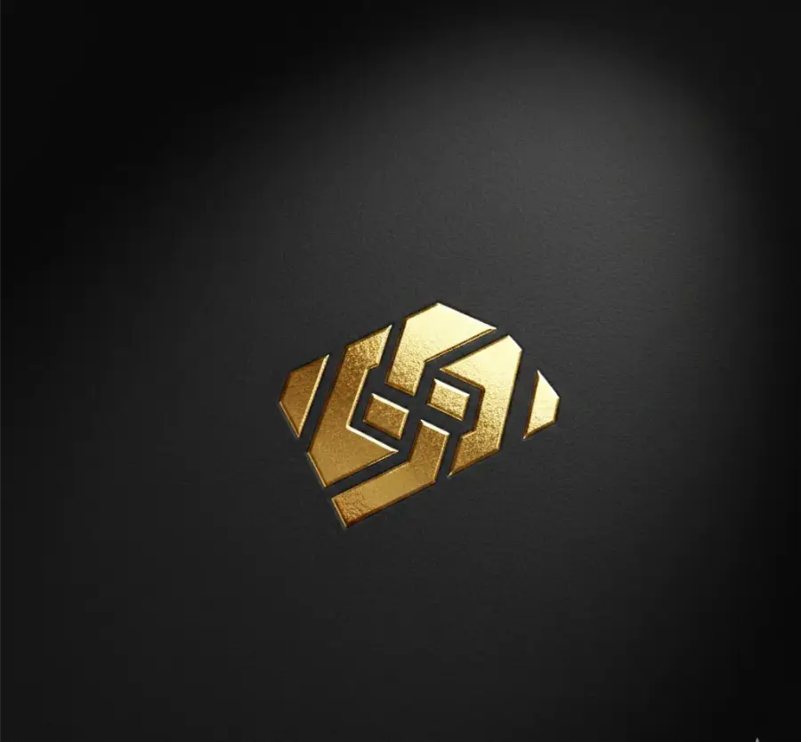 A gold geometric monogram, embossed on dark textured card and lit from one side.